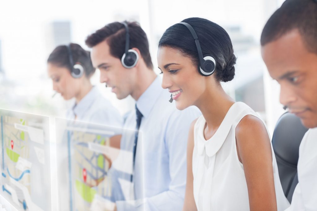 Call center employees at work on futuristic hologram interfaces in bright modern office