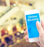 Hand holding mobile with online booking with blur background, Digital Booking concept.