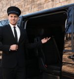 Professional driver near luxury car. Chauffeur service
